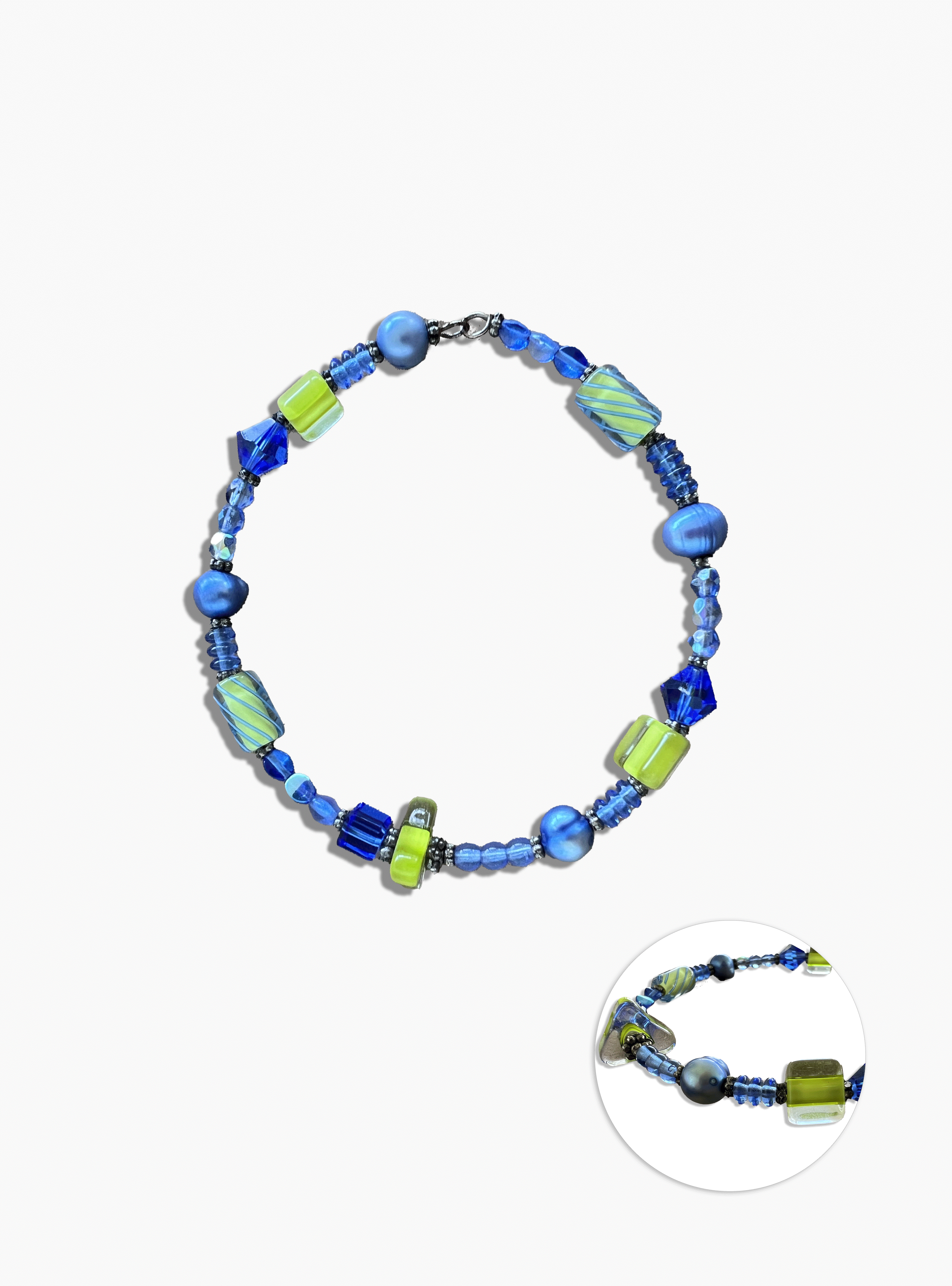 Beaded necklace with blue and green beads on a white background