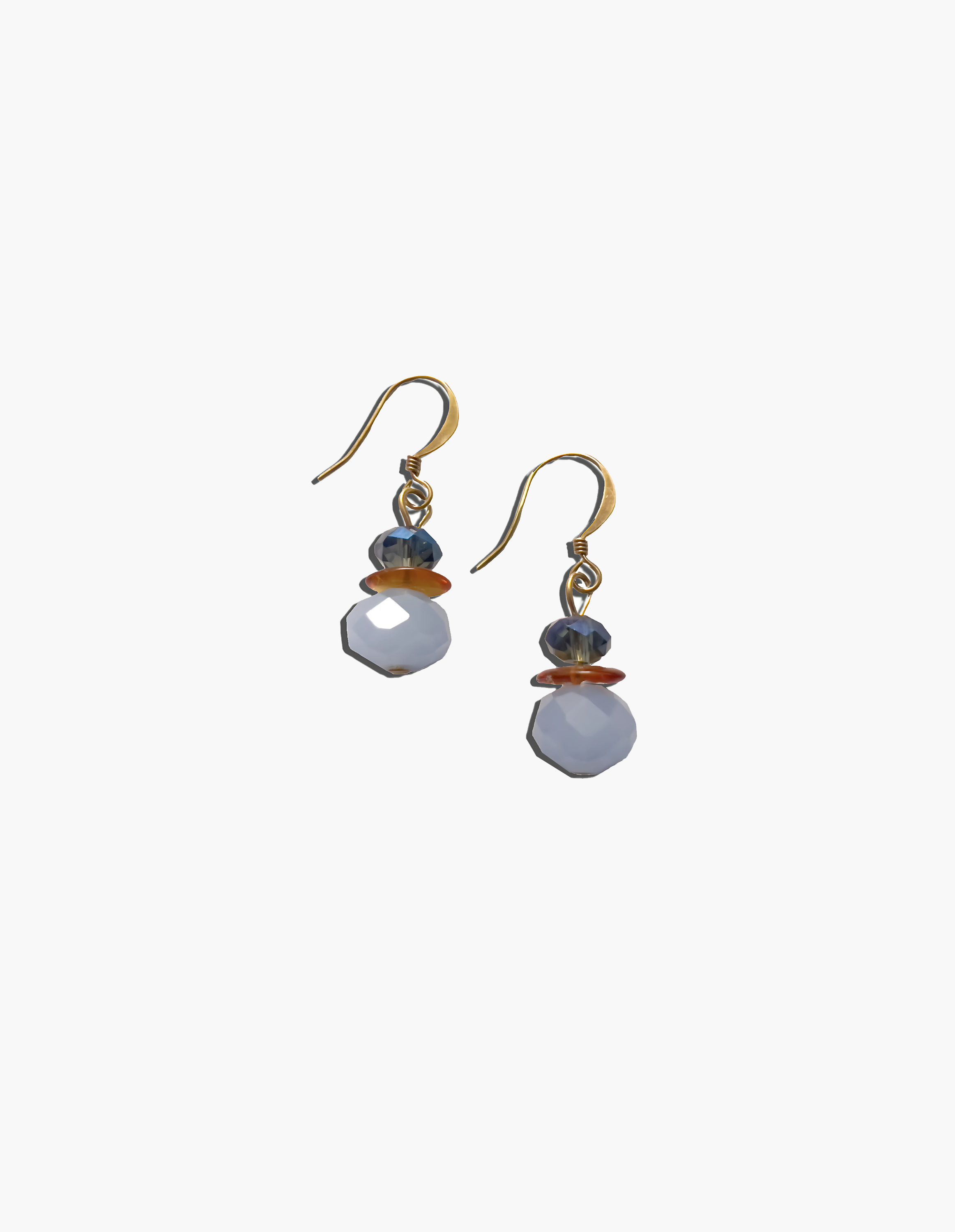 Pair of earrings with white beads and gold accents on a white background